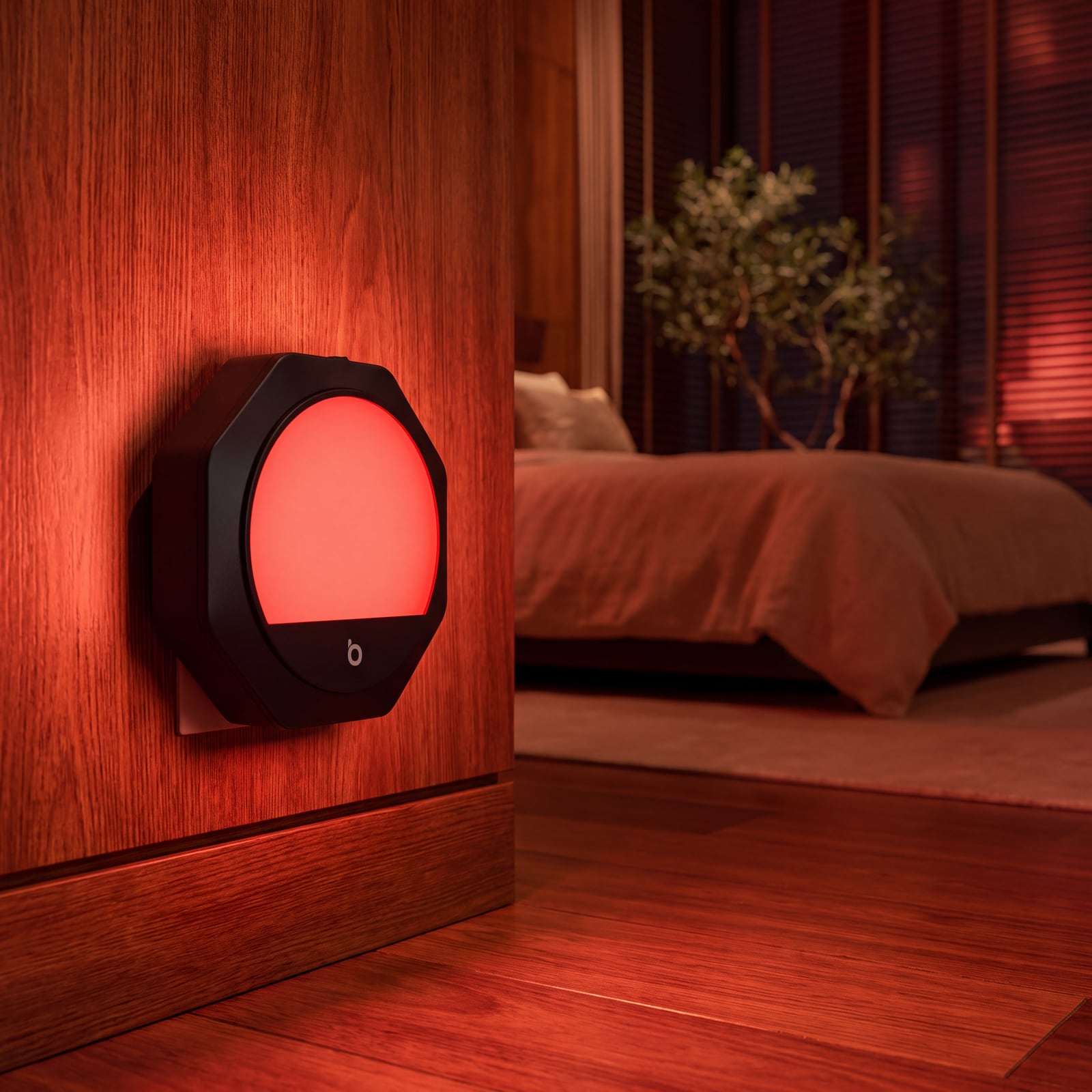 Uma luz noturna vermelha de tomada brilhando na parede de um quarto